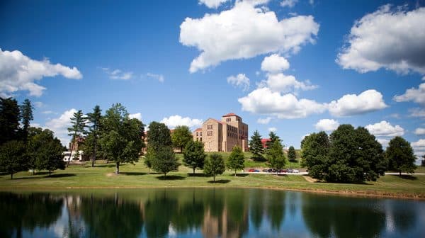 Scenic view of Saint Meinrad Archabbey overlooking pond during sunny day