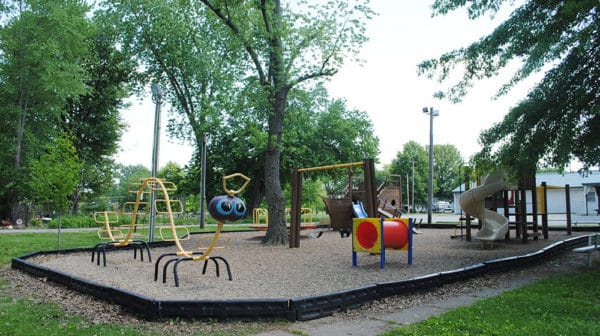 Playground equipment at community park in Dale, Indiana, with green trees in background