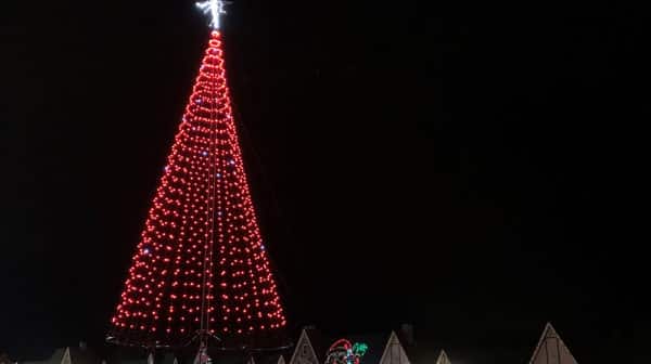 LED tree is lit up red against a night sky
