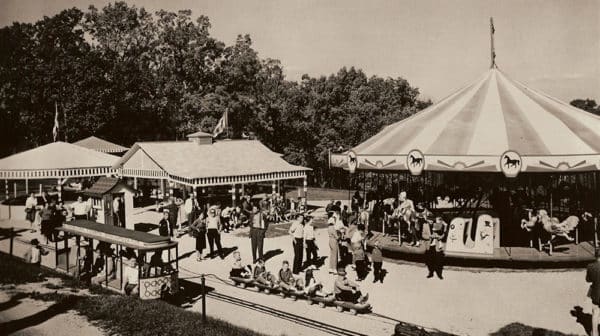 Black and white photo shows families enjoying train rides and a merry-go-round in the early days of Santa Claus Land