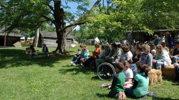 A gathered crowd watches costumed interpreters during Spring Heritage Day at Lincoln Pioneer Village & Museum