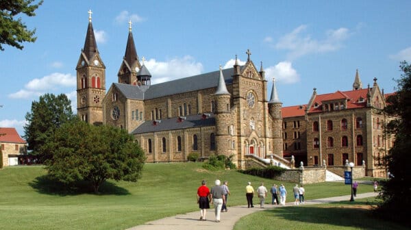 Group of people walk past the Archabbey Church at Saint Meinrad Archabbey