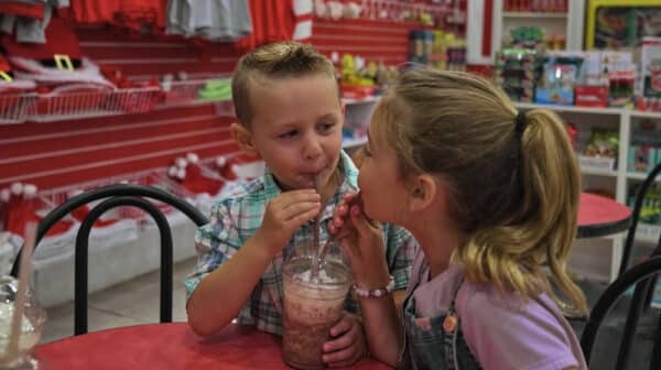 A boy and girl share a frozen hot chocolate at Santa's Candy Castle