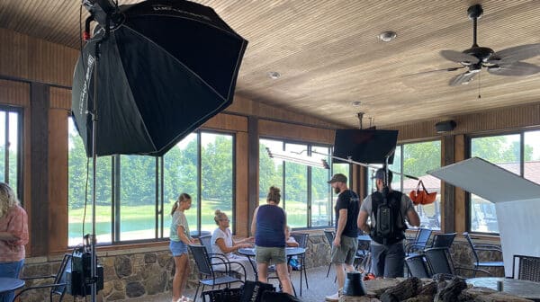 Mom and two kids converse with camera crew as they prepare to shoot a destination video scene at The Rustic restaurant