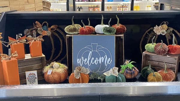 Fall product display at Beloved Farms features fabric and wood pumpkins and pumpkin-themed welcome sign