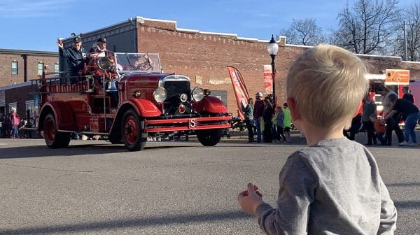 Young child is shown from behind watching the Rockport Christmas Parade
