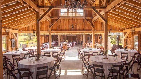 Interior of Corner House Event Barns is shown with multiple round tables set up