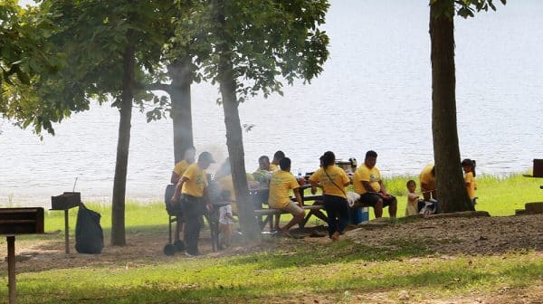 Group of people in yellow shirts sits at a picnic table beside the lake at Lincoln State Park
