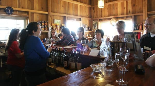 Group of men and women stand at the bar at Monkey Hollow Winery and Distillery enjoying wine tastings