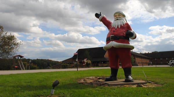 Large Santa statue stands in foreground with Santa's Lodge in background