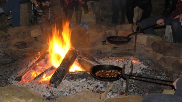 Two pans of chestnuts are held over a fire during the Chestnuts Roasting on an Open Fire event at Santa's Candy Castle